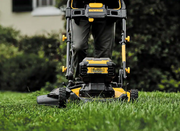 Podadora de césped DEWALT inalámbrica vista frontal con batería sobre el césped