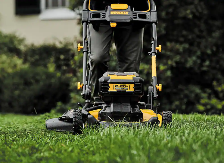 Podadora de césped DEWALT inalámbrica vista frontal con batería sobre el césped