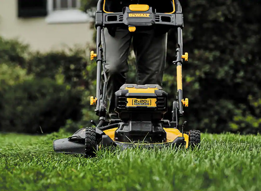 Podadora de césped DEWALT inalámbrica vista frontal con batería sobre el césped